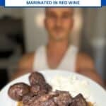 niko holding a plate of cooked afelia pork