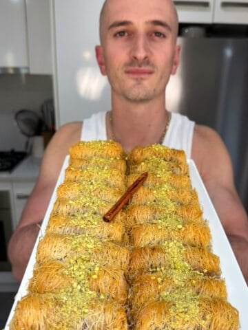 niko holding a tray of kataifi rolls ready for eating