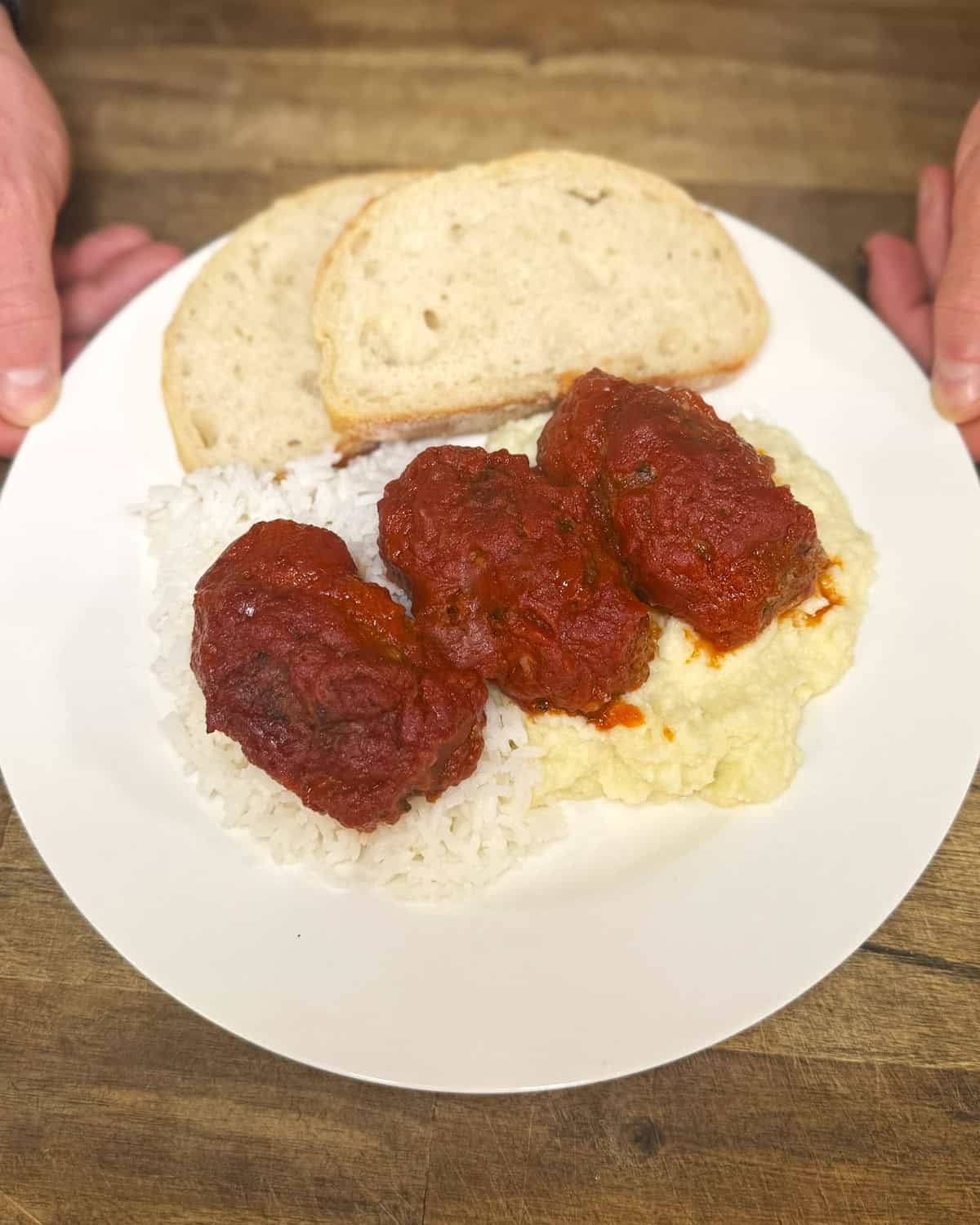 soutzoukakia on a plate with bread, rice and mash