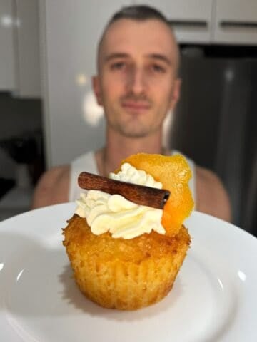 niko holding a greek orange cupcake garnished with cream, orange and cinnamon