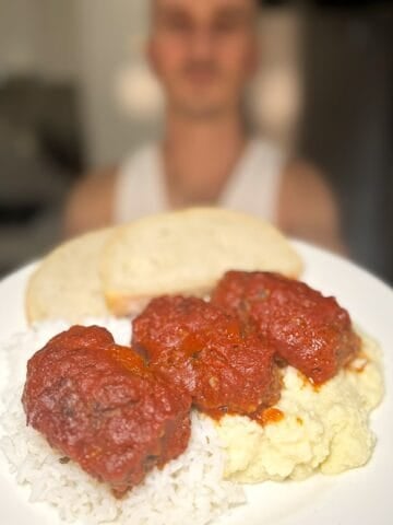niko holding a plate of soutzoukakia in tomato sauce