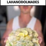 niko holding a plate with cooked lahanodolmades ready for eating